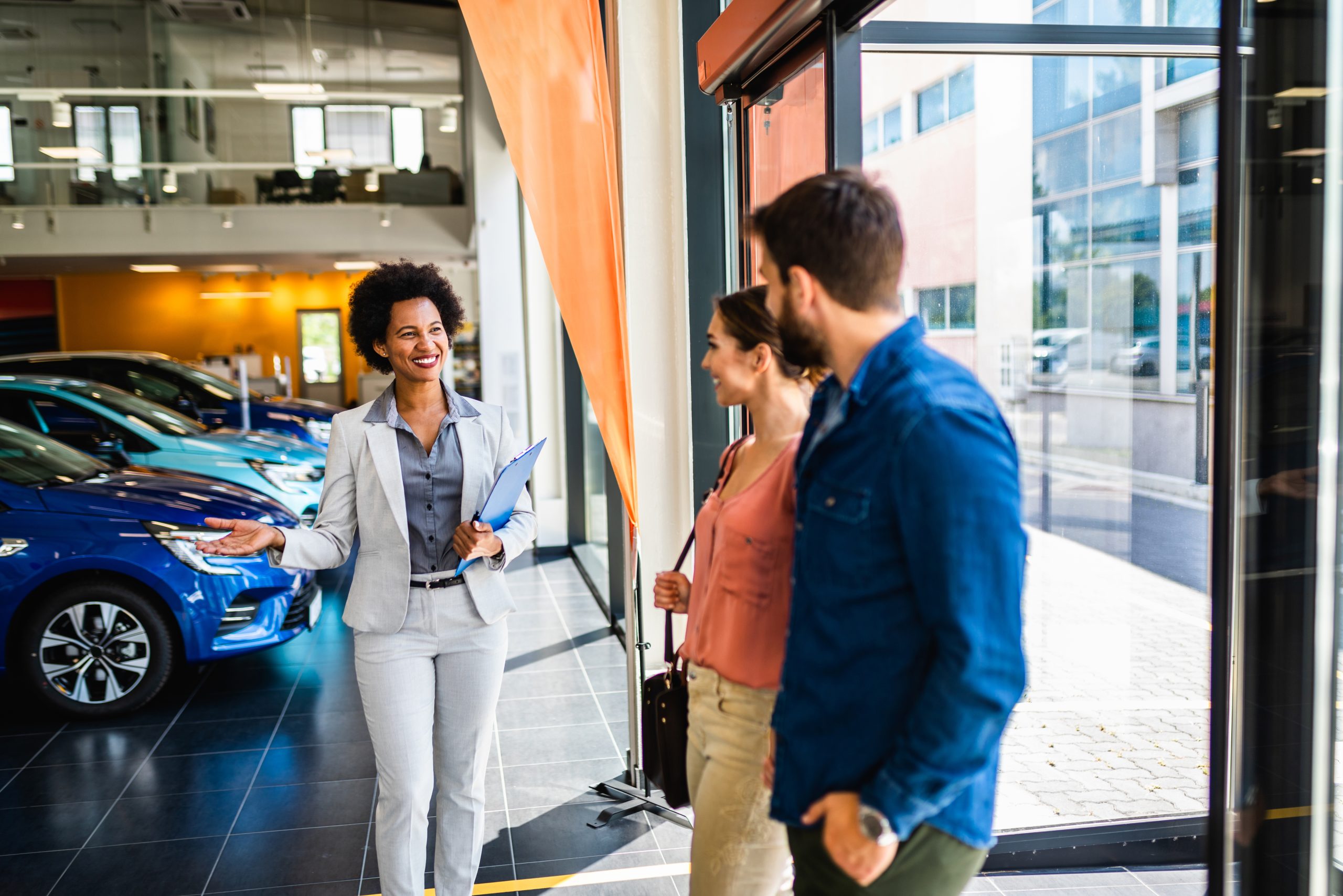 Young couple walking into a used car showroom