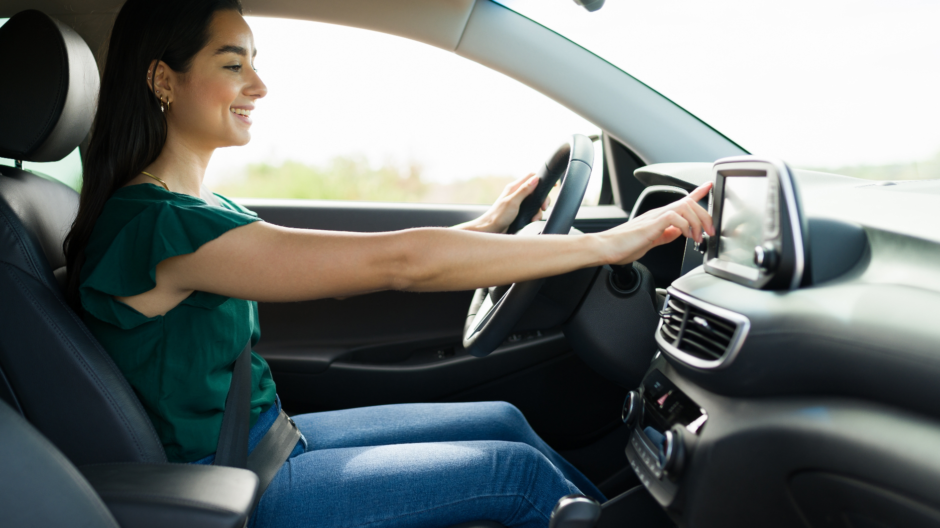 Happy young woman enjoying her used vehicle's features