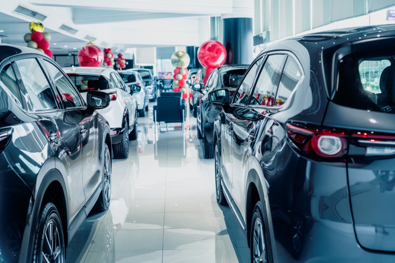 The interior of a car dealership showroom, with many vehicles on display.