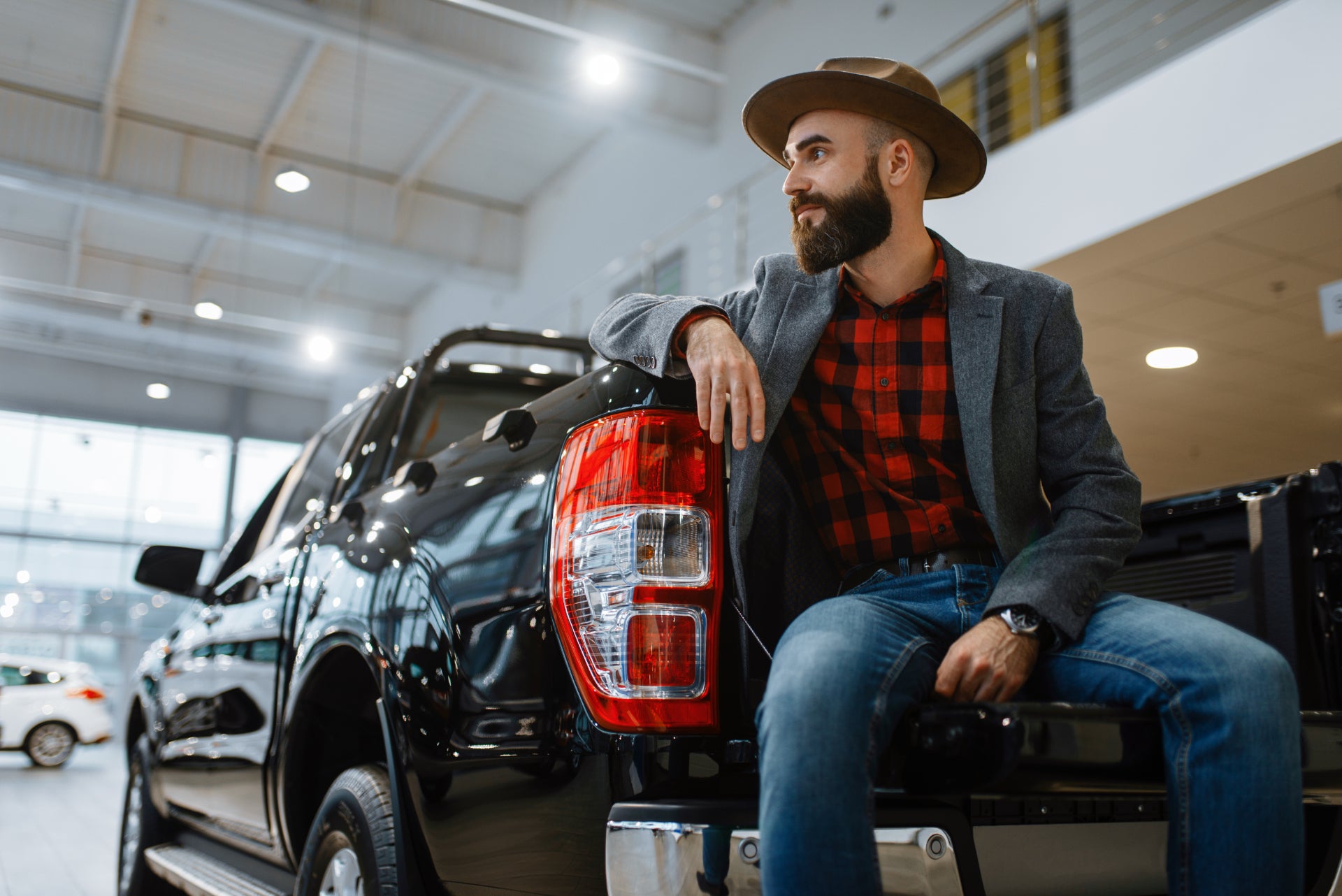 A grinning man sitting in the bed of his truck