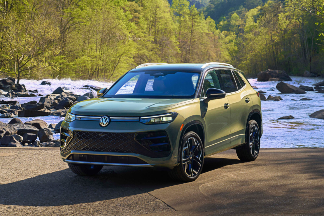 A green Volkswagen Tiguan parked by a river in a river.