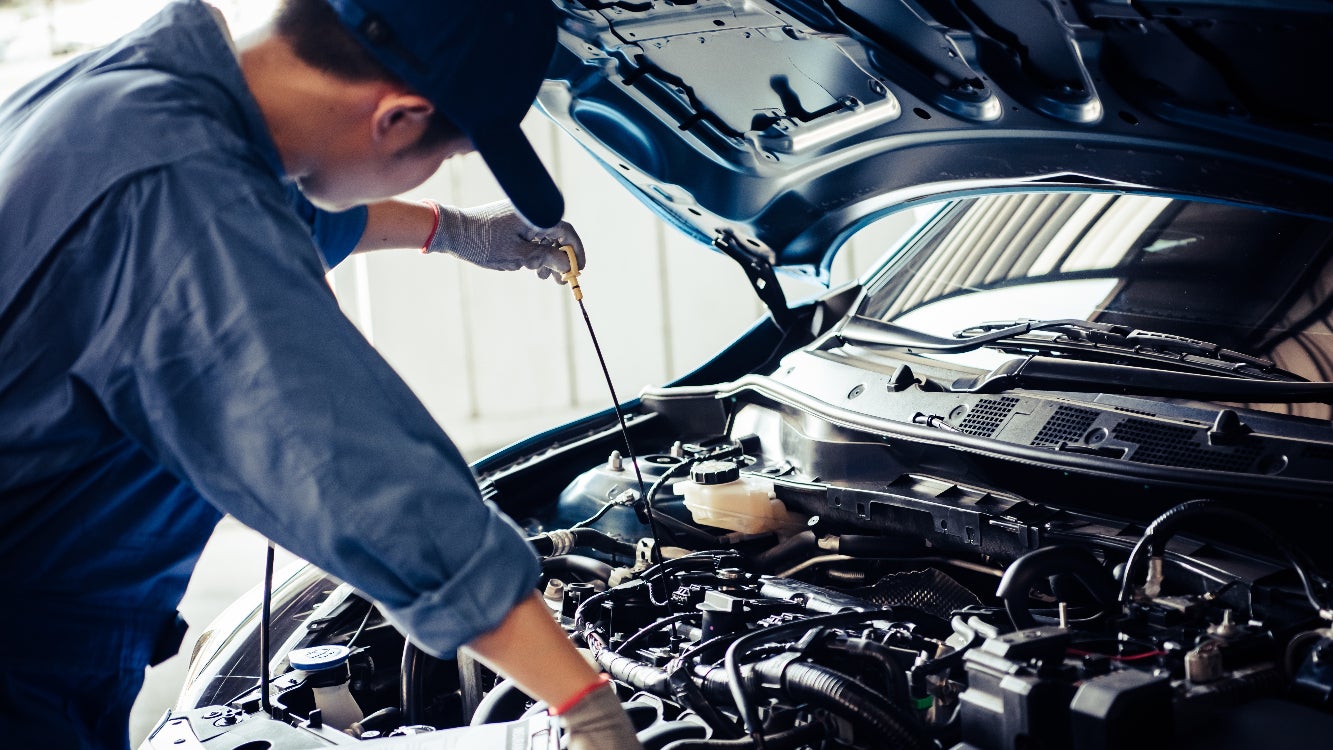 Technician performing an oil check on an engine