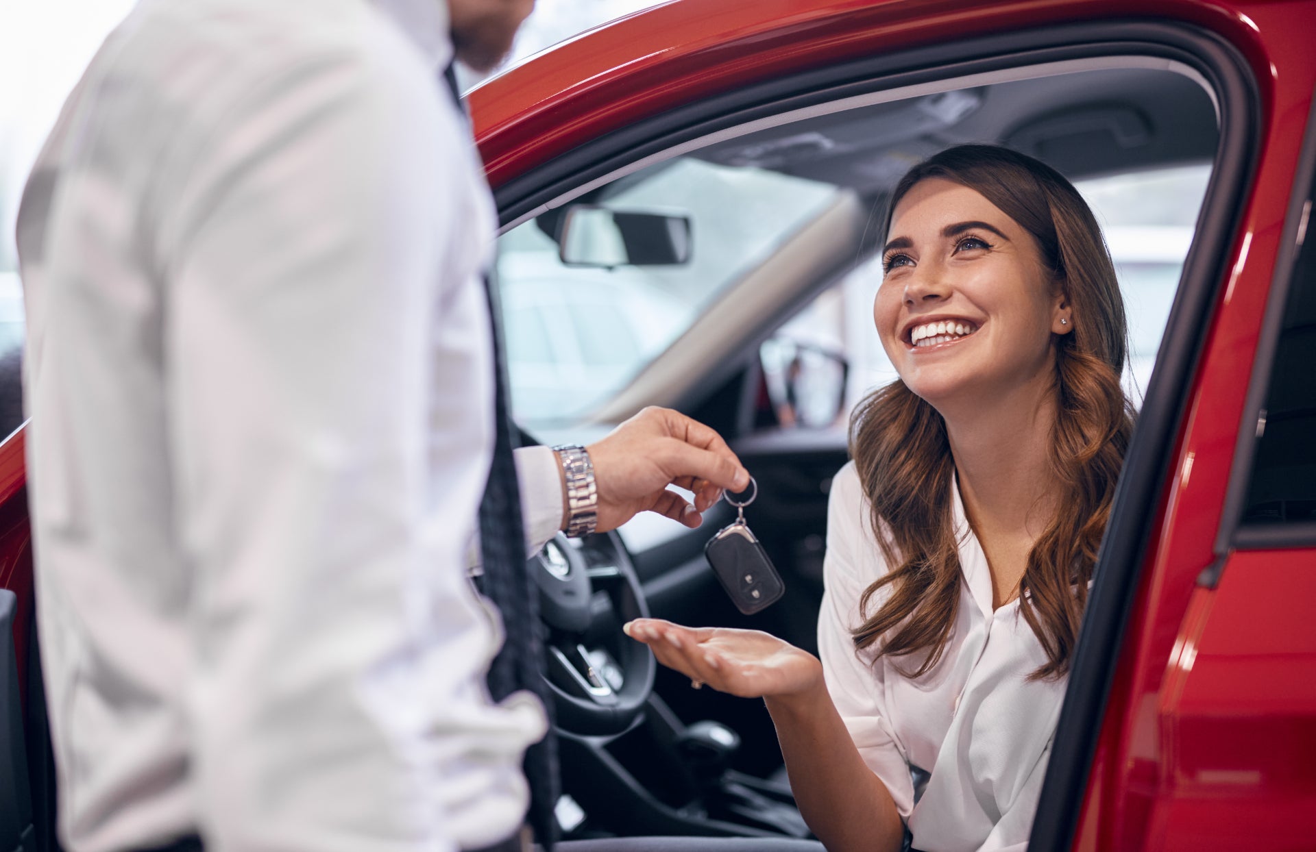 Smiling woman getting the keys to her used RAM